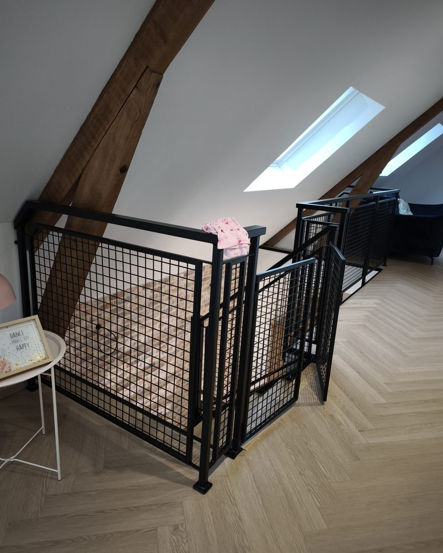 Garde-corps de mezzanine en maille d’acier noir sous charpente bois apparente